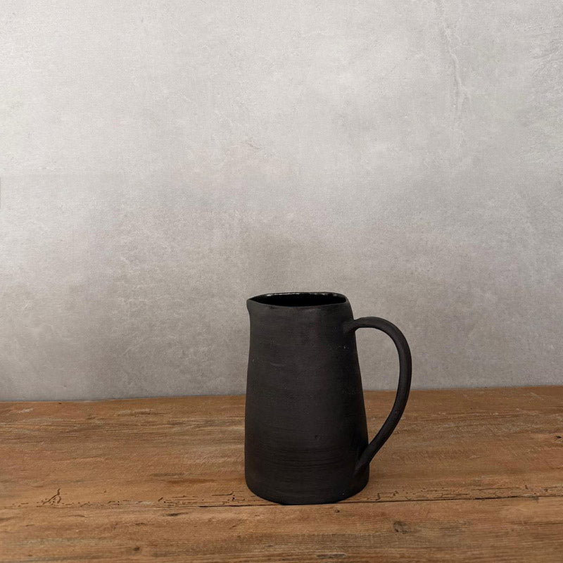 JOLO Keramikkrug handgetöpfert, H 14 cm, schwarzer unglasierter Steinzeug, eleganter Henkel, auf rustikalem Holztisch, Hofkirchen OÖ